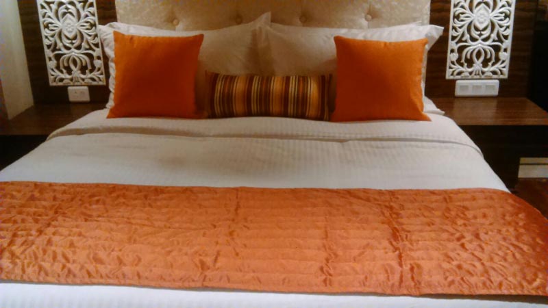 Orange silk fabric bed runner.